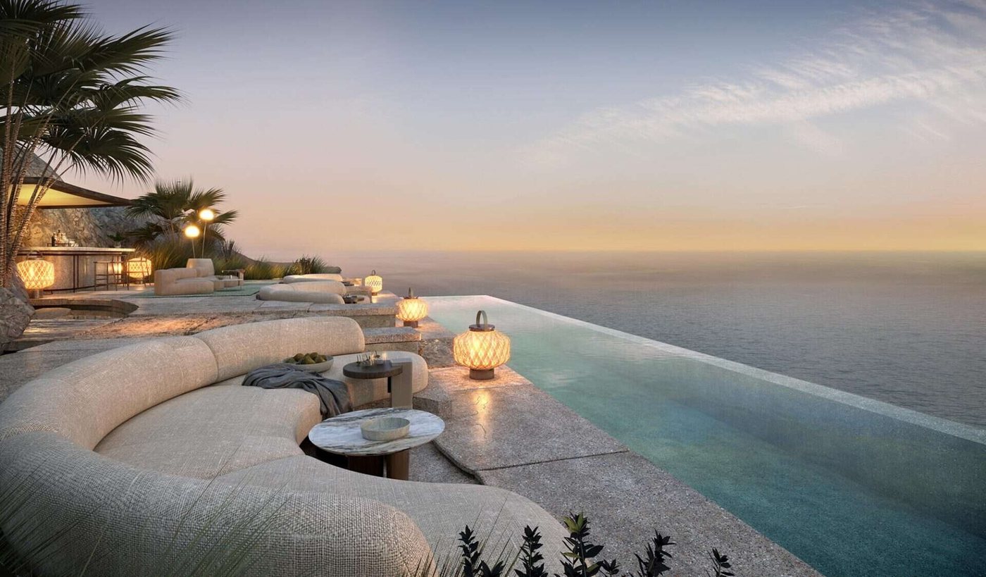 Lounge by an infinity pool above the sea at sunset